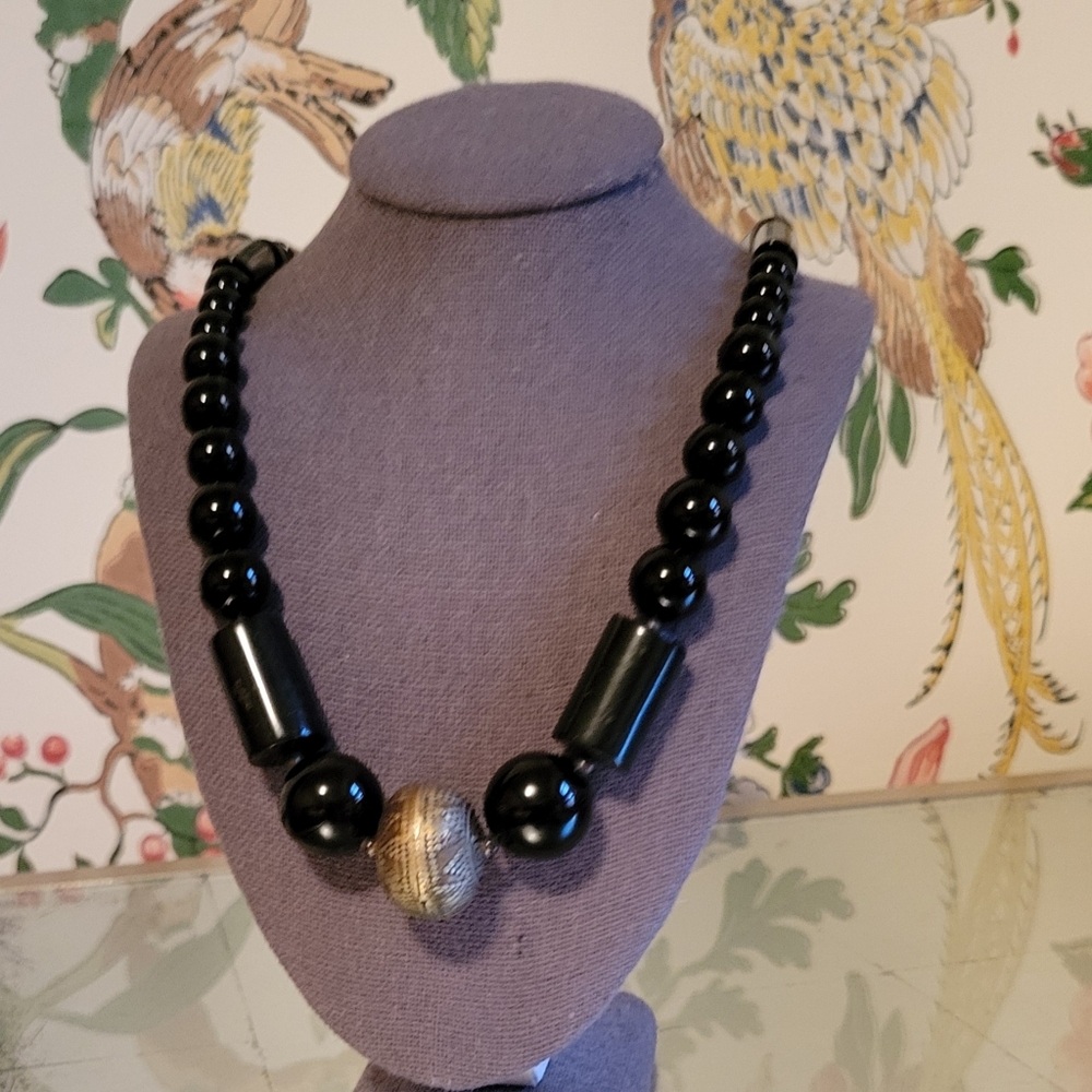 Black geometric bead necklace w/silver-tone metal bead. 19 inches long.